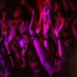 Vibrant concert crowd with hands up, capturing the energy and excitement of the event.